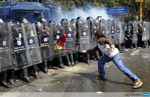AnonymousVene10's tweet photo. Aquí se puede apreciar a estudiante fascista agrediendo a los honorables oficiales con un arma de destrucción masiva http://t.co/GYn6IgOJHn