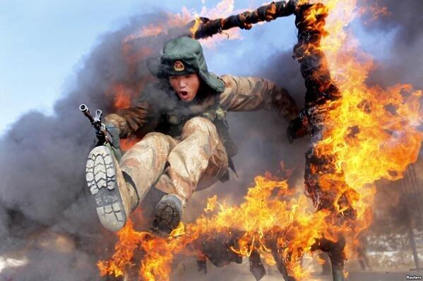 militarypic's tweet photo. Chinese soldier jumping trough a wall of fire http://t.co/DWFnwLS6qP