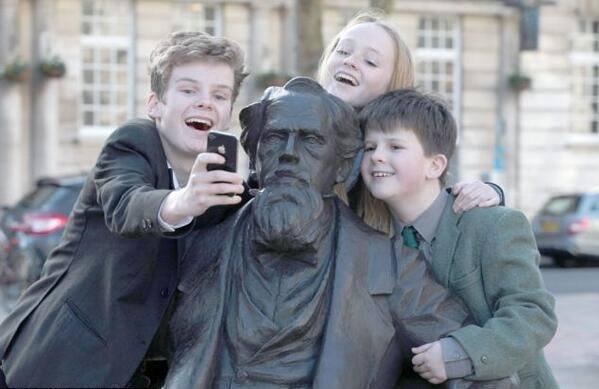 أحفاد أحفاد أحفاد الكاتب الروائي تشارلز ديكنز يلتقطون صورة مع تمثال جدهم فى عيد ميلاده ال 202 :))