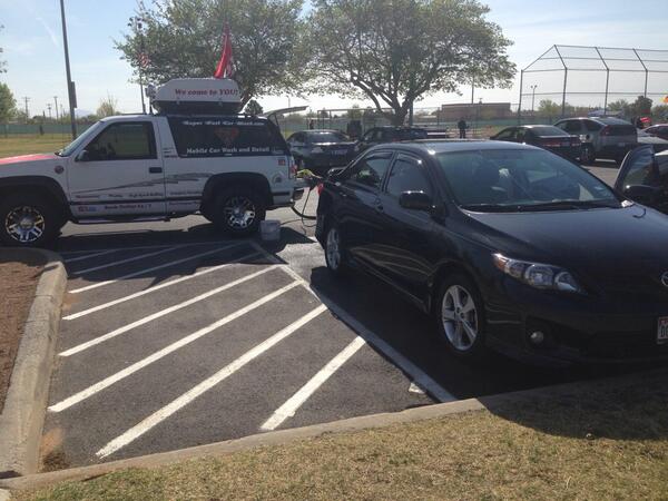 Getting her car done, while she watches her son play baseball....