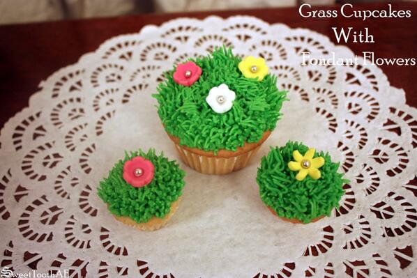 SweetToothAE's tweet image. Grass cupcakes with Fondant Flowers