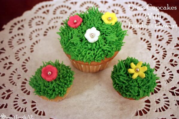 SweetToothAE's tweet image. Grass cupcakes with Fondant Flowers