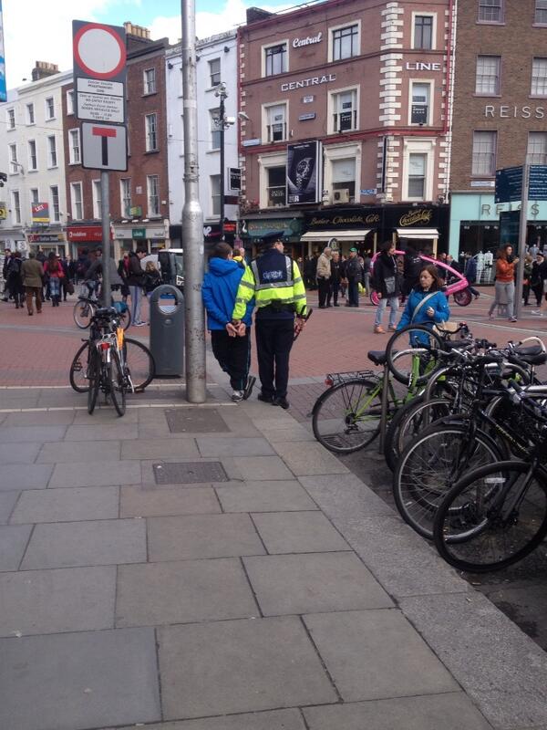 Bike thief in cuffs, while a Garda holds his bolt cutters. Sound.