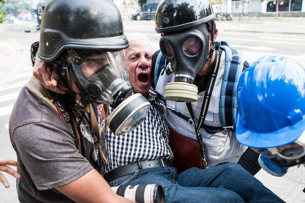 AnonymousVene10's tweet photo. Reporteros gráficos asisten en víctimas en represeión de policias en #Ccs http://t.co/yS3NM2LlYM #1AParoNacional