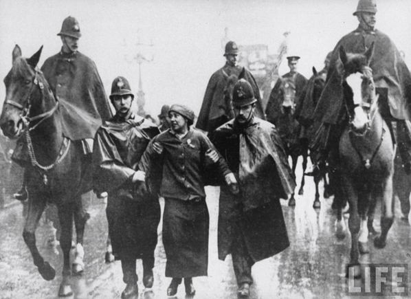 FeministPics's tweet photo. Sylvia Pankhurst being arrested outside Charing Cross station to stop her speaking in Trafalgar Square, 8 March 1914. http://t.co/UFGCKPoks0