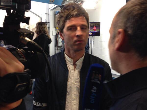FOTO: Noel Gallagher mendapat ban kapten aseli <a href="/VincentKompany/">Vincent Kompany</a> pada pertandingan tadi sambil diwawancara. #mcfc