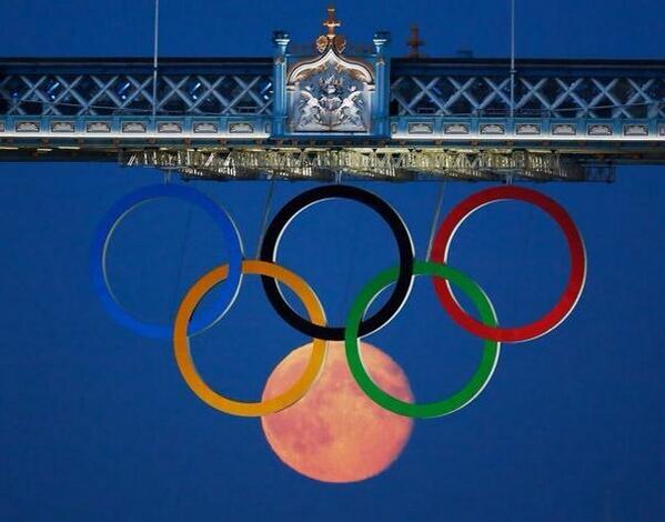 Perfectly timed photo of the full moon rising through the Olympic Rings hanging beneath Tower Bridge during the Lond…