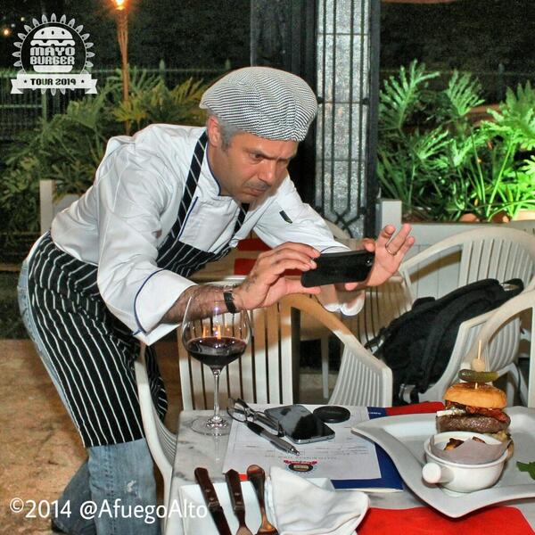 "Detrás de cámaras" en el #MayoBurgerTour2014:  Carlos Estevez de <a href="/labohemebistrot/">La Bohème Bistrot</a> tira una foto a su hamburguesa.