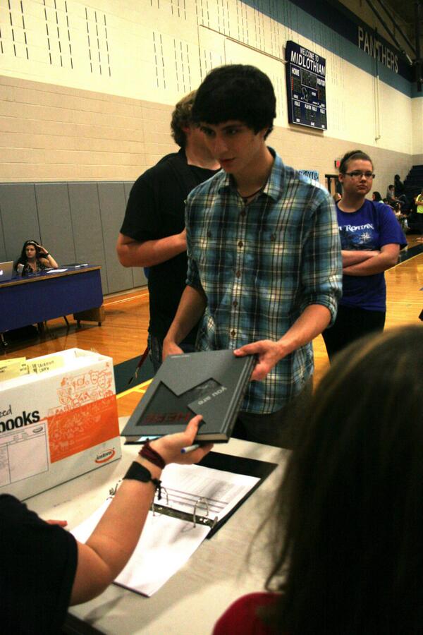 Senior Jacob Wrobel is one of the first seniors to get his 2014 yearbook at the Distribution Party.