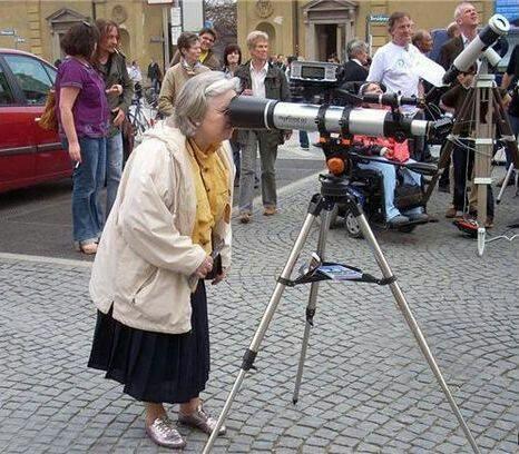 Woman looking through the wrong end of a telescope