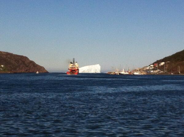 cbcsalima's tweet photo. I wonder which one's bigger. Giant berg in DT St. John's #cbcnl http://t.co/NqoJbbit6Y