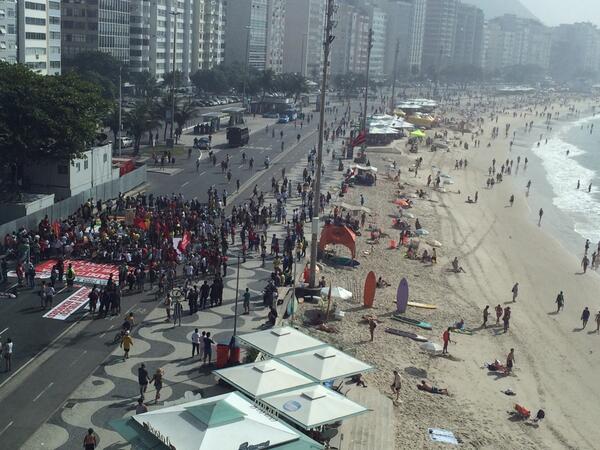 GaryLineker's tweet photo. The juxtaposition of life in Brazil at FIFA's World Cup. Making a stand on one side. Enjoying the sand on the other. http://t.co/ORAtMR9Y8C