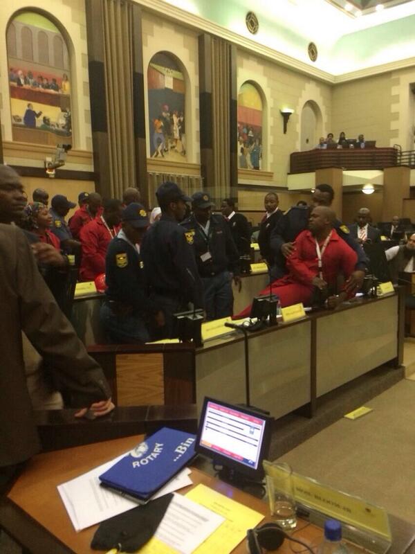 DrCamModisane's tweet photo. BREAKING NEWS: EFF MPs are removed by police from the GP Legislature due to wearing red overalls. Cc @EconFreedomZA http://t.co/my6zw6bB3D