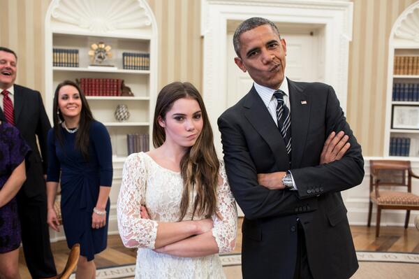 Obama poses with someone with arms crossed