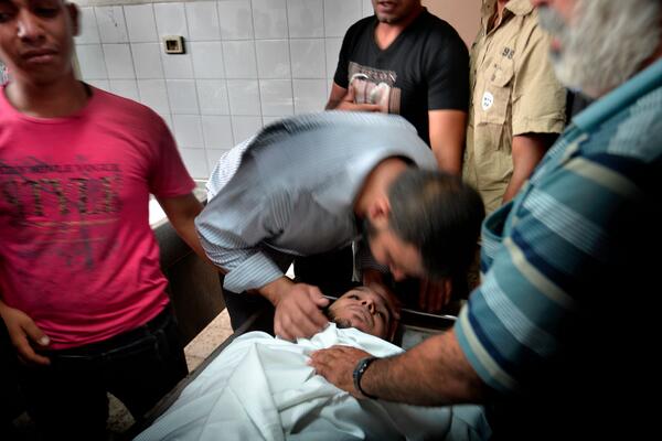 hhenden's tweet photo. Relatives mourning their dead after 17 people from a single family was killed in an Israeli bombing raid last night. http://t.co/Is284Nb1gP