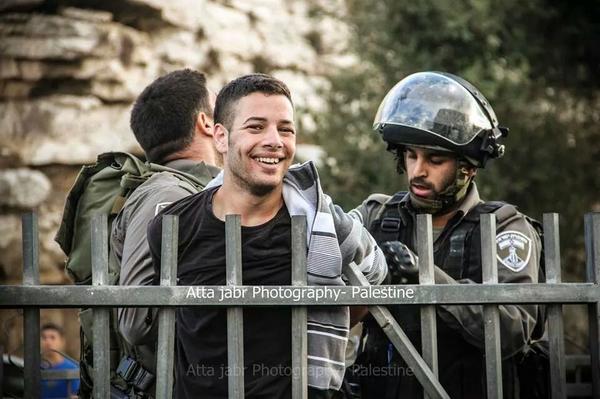 شاب فلسطيني.. لا يخيفه جنود الاحتلال ولا يرهبه الاعتقال.. يضحك لحظة اعتقاله BtKdAA4IEAAVE9L