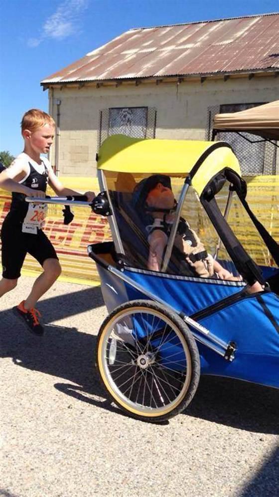 TODAYshow's tweet photo. 'Extraordinary' little boy finishes triathlon with his disabled brother #GoodNews http://t.co/J5rnKLvlhZ http://t.co/BPKwu6lPbp