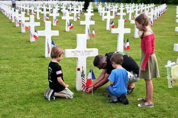 French people putting flowers on a grave of an American soldier at Normandy American Cemetery #dday70 #abmc