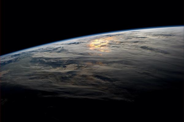 astro_reid's tweet image. Sunset over the Pacific creates a sea of orange beneath the clouds.