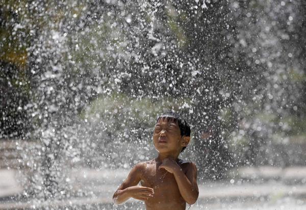 arshadsmohi's tweet photo. A boy cools down in a water fountain during a hot day at a park in #Tokyo @InfoMumbai http://t.co/f5lLnmSX6R