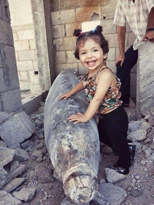 Mogaza's tweet photo. The #Israeli missile that hit and didn't explode made a child smile that they are still ALIVE! http://t.co/AogH7U1GHL #Gaza