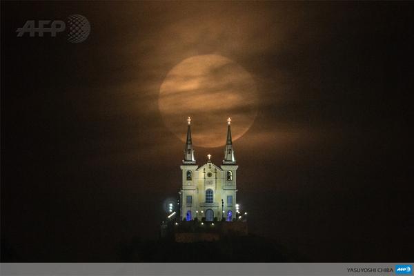 afpfr's tweet photo. #instantané Superbe vue de la pleine lune venant se placer derrière l'église Nossa Senhora da Penha, à Rio #AFP http://t.co/Mxe9c9Y7NU