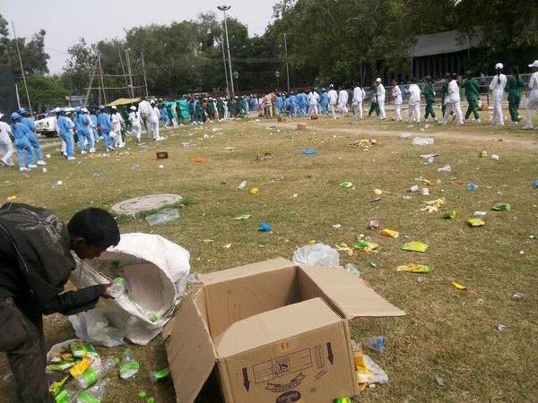 Young ragpicker cleans up litter strewn by students/citizens who were applauding PM Modi when he spoke of cleanliness