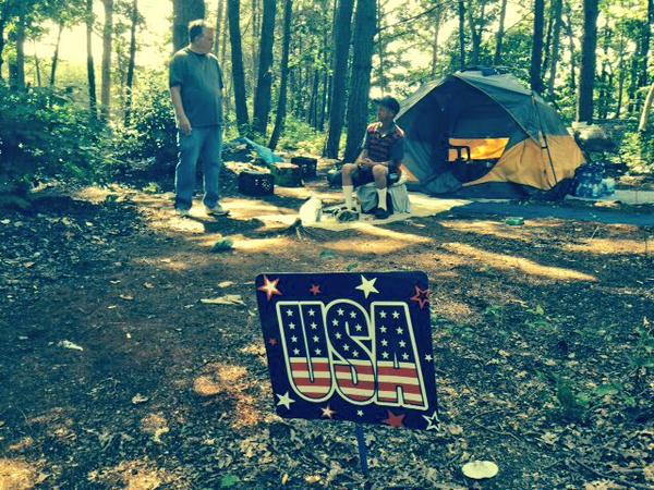 Our volunteer Dominic with a friend we found Saturday. The sign, sadly, says a lot.