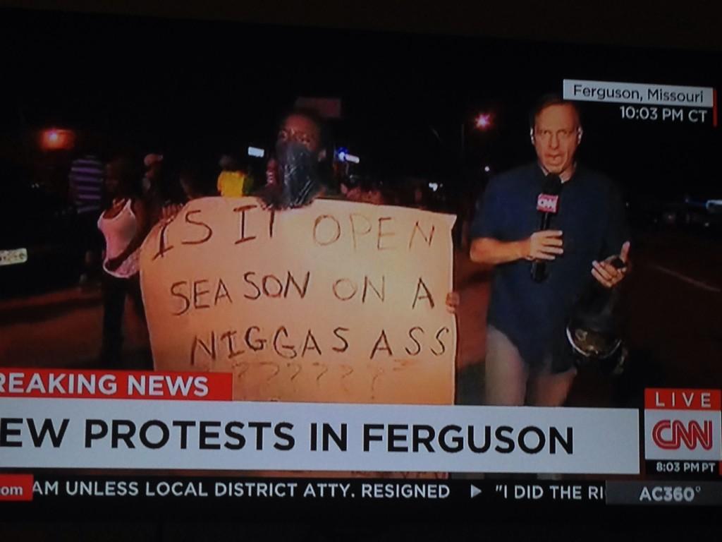 Ferguson sign 'is it open season on a niggas ass' next to Jake Tapper