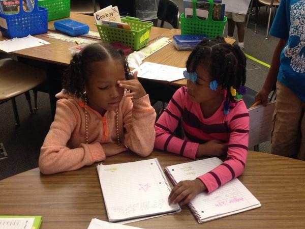 Sharing their writing with a friend. #championsforchildren #nwe