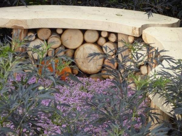 Love this idea for a curved wooden bench, doubled up as a log habitat for insects. #insecthotel #organicgardening