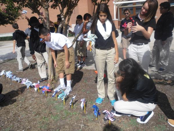 ARTrcms's tweet photo. Students adding pinwheels for the display in front of our school. http://t.co/b3vO1xjvIS