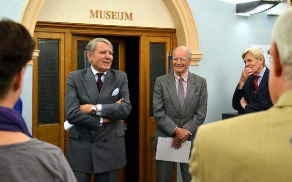 Sir Thomas Sopwith's son, Tommy Sopwith (left), unveils the bust at a ceremony in Kingston Library on 25 September 2014. Also pictured (centre) is the sculptor Ambrose Barber.