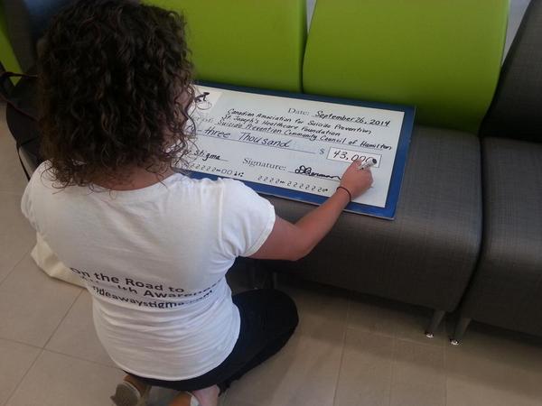 StJoesHamilton's tweet photo. Danielle from @RideAwayStigma signing the $43,000 cheque to her charity partners @STJOESHAMILTON @CASP_CA #SPCCH http://t.co/S726CjjRz3