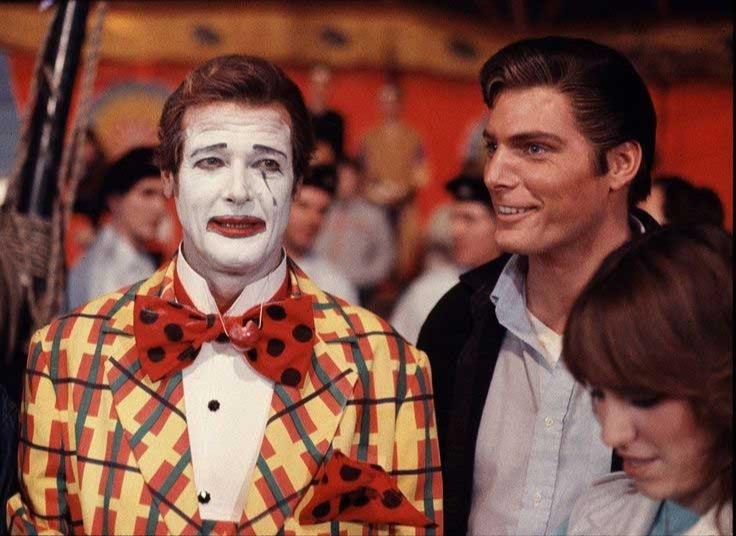 Happy 87th Birthday Roger Moore!!! Here in Clown costume being visited by Christopher Reeve on the set of Octopussy 