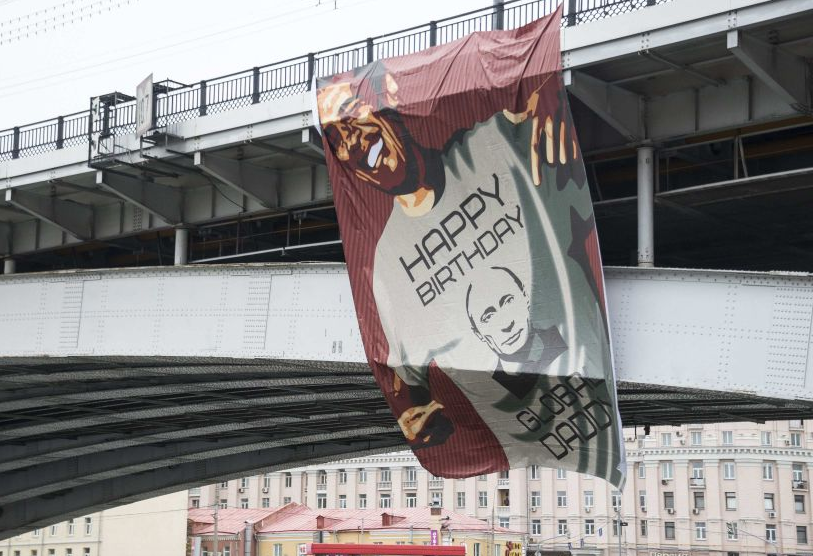 A banner depicting Obama wearing a T-shirt wishing Vladimir Putin a happy birthday, hangs on a bridge in Moscow 