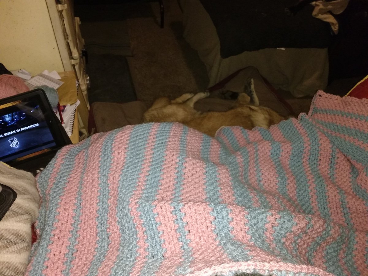Crocheted blanket in pink and blue stripes.