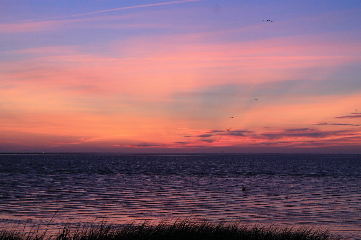 An orange and pink sunset above the Atlantic shore
