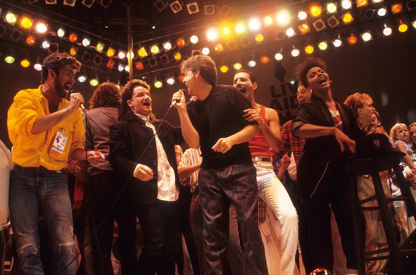 BoredWeb3's tweet photo. George Michael with Bob Geldof, Bono, P. McCartney, Freddie Mercury and  A. Ridgley  performing at Wembley Stadium, 1985. Pic by Neil Leifer https://t.co/c9o6XQZTFG