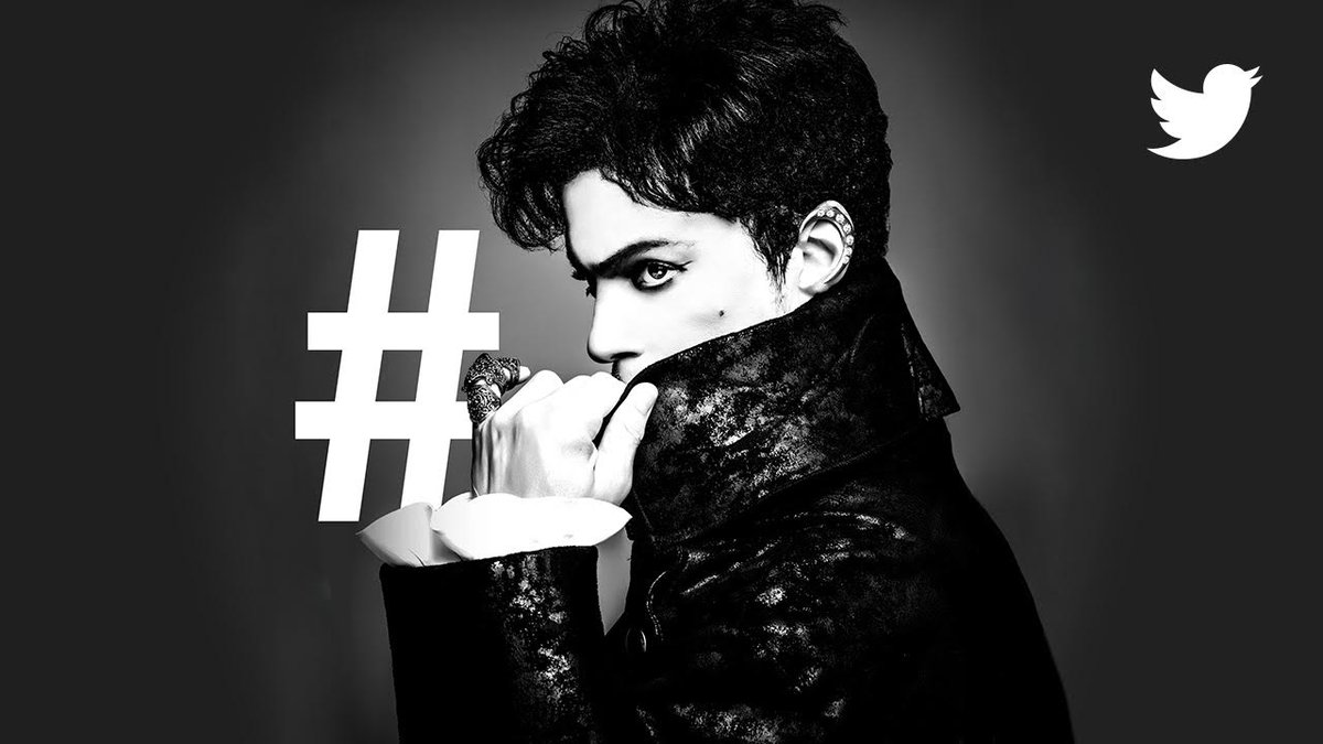 Black and white portrait of the late musician Prince, with a hashtag symbol behind him