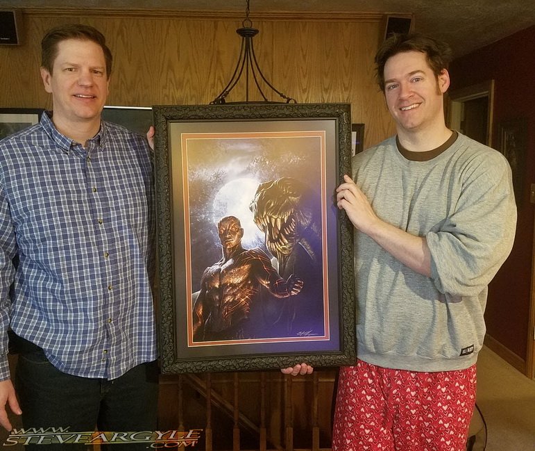 Steve_Argyle's tweet photo. Got a visit from @Vincent_Riddle, author of “Mask of the Wizard” to pick up a print! I am in my full-power-lazy New Years recovery attire. https://t.co/iUjoNwsOrT