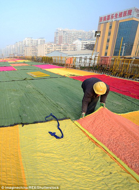 Chinese construction workers put more than 100 colourful quilts on a newly paved road to 'keep it warm' dailym.ai/2i3eDmv