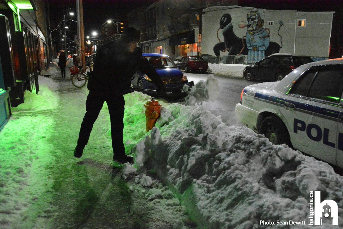 haligonia's tweet photo. An HRP officer takes a few moments to dig out a fire hydrant on Gottingen St during a chilly night patrol https://t.co/n2kHDGWisK