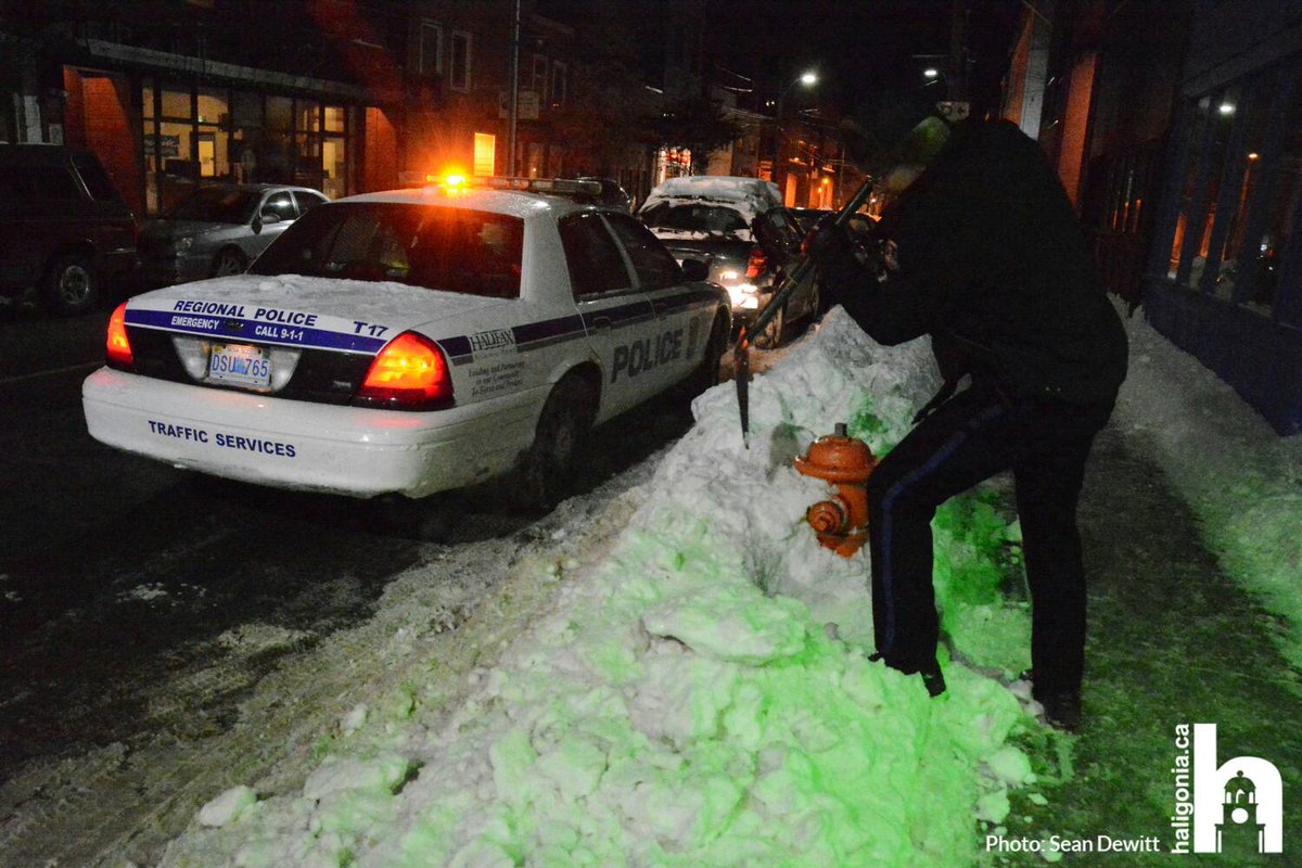 haligonia's tweet photo. An HRP officer takes a few moments to dig out a fire hydrant on Gottingen St during a chilly night patrol https://t.co/n2kHDGWisK