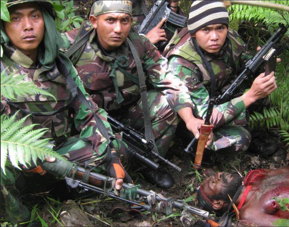 Indonesian soldiers pose for a "trophy photo" after murdering a tribesman in the highlands of #WestPapua