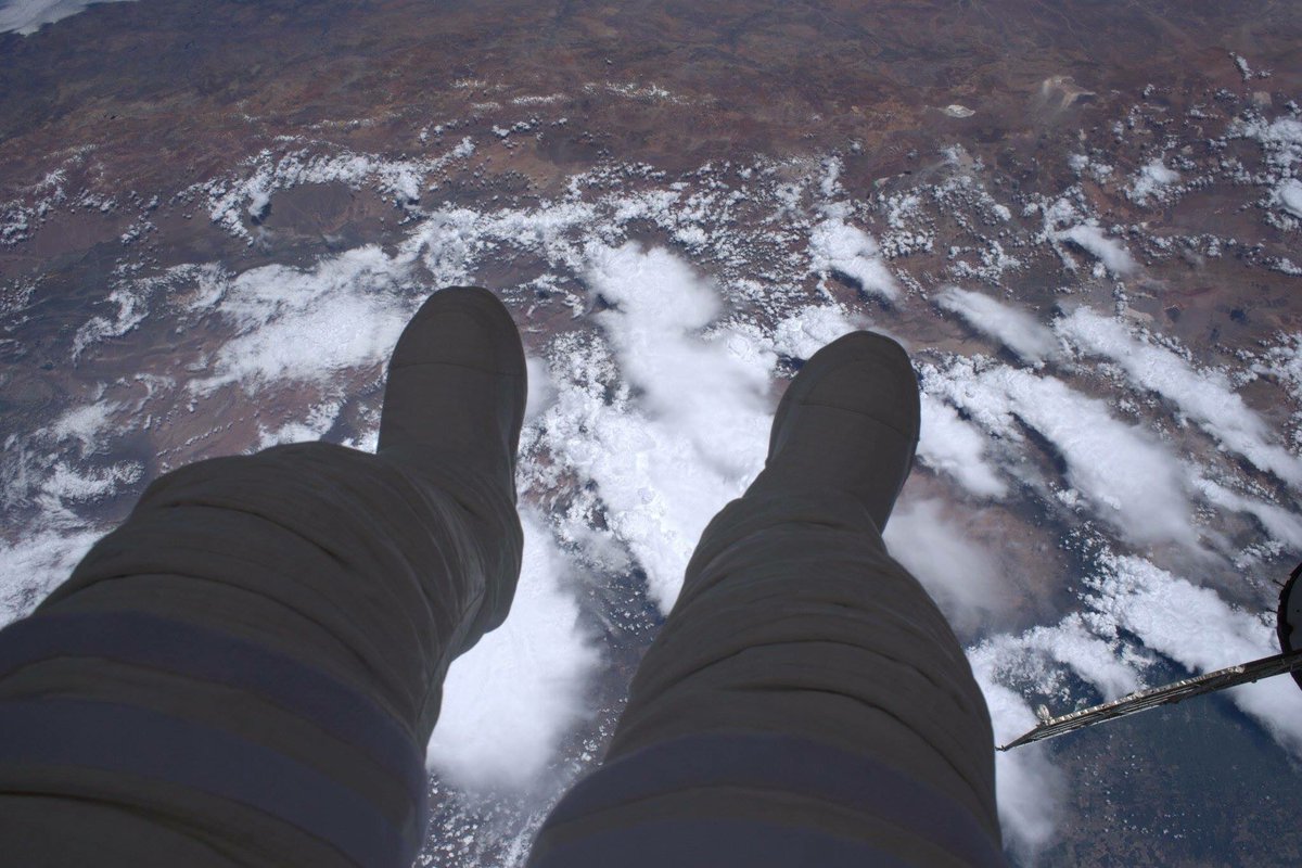 Thomas Pesquet's feet hovering above the Earth during a spacewalk