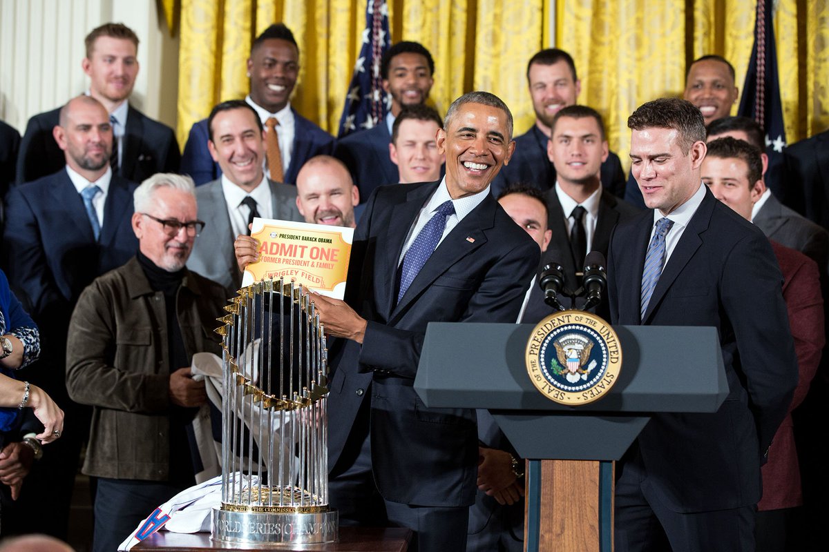 ObamaWhiteHouse's tweet photo. “As a new fan, you have some catching up to do.” The @Cubs present @POTUS with a lifetime pass to Wrigley Field. https://t.co/Y9RbjqVK29