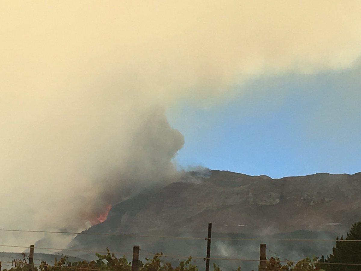 ewnreporter's tweet photo. #PaarlFire As the smoke starts to clear (due to calmer winds) the devastation and flames become visible. IM https://t.co/QWaEd4z0ey
