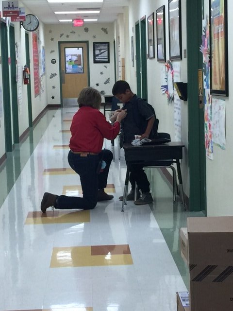 NISDmartin's tweet photo. Principal Cobarruvias on bended knee helping a student button his shirt correctly. #KidsDeserveIt #jobduties https://t.co/EvhuE48qUo