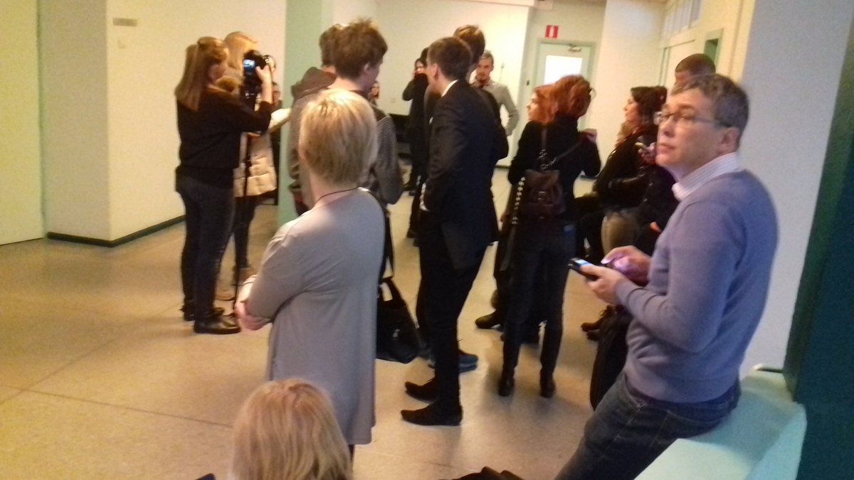 trtram's tweet photo. Uks sulgus paksu kitlis mehe selja taga. Algab kirjandusseminar kohtumaja koridoris. #untitled12 #liivalaia24 https://t.co/GUd4YGWtpl